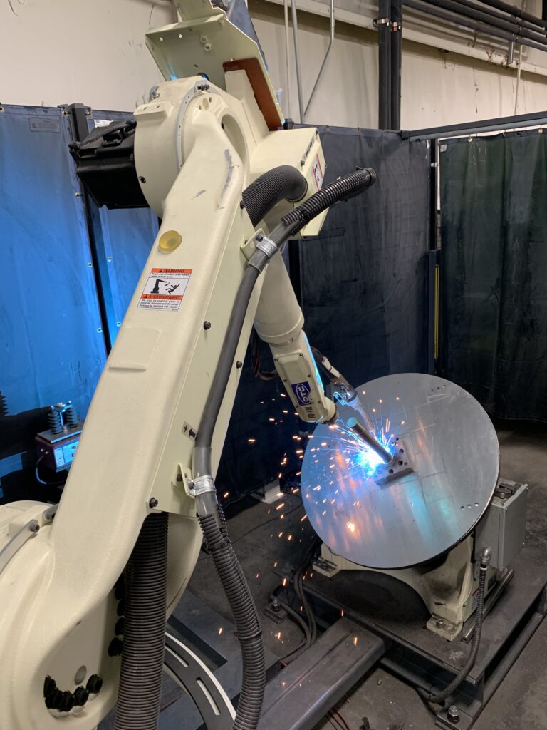 A robot is welding a disc on top of a table.